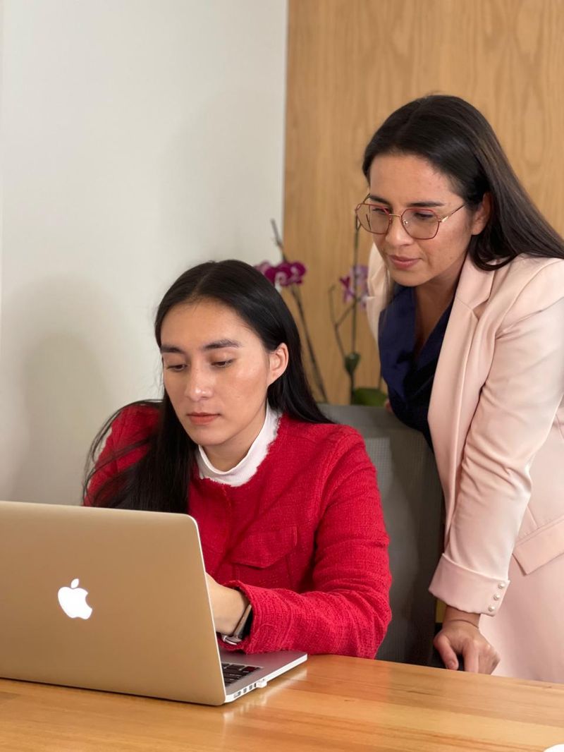 Las hermanas Granada revisando un informe en el computador